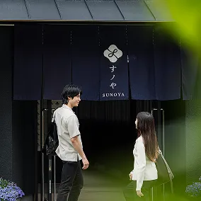 ホテルの入り口に立つ若い男女