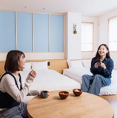 客室で寛ぐ女性2人。お茶を飲んで談話している様子